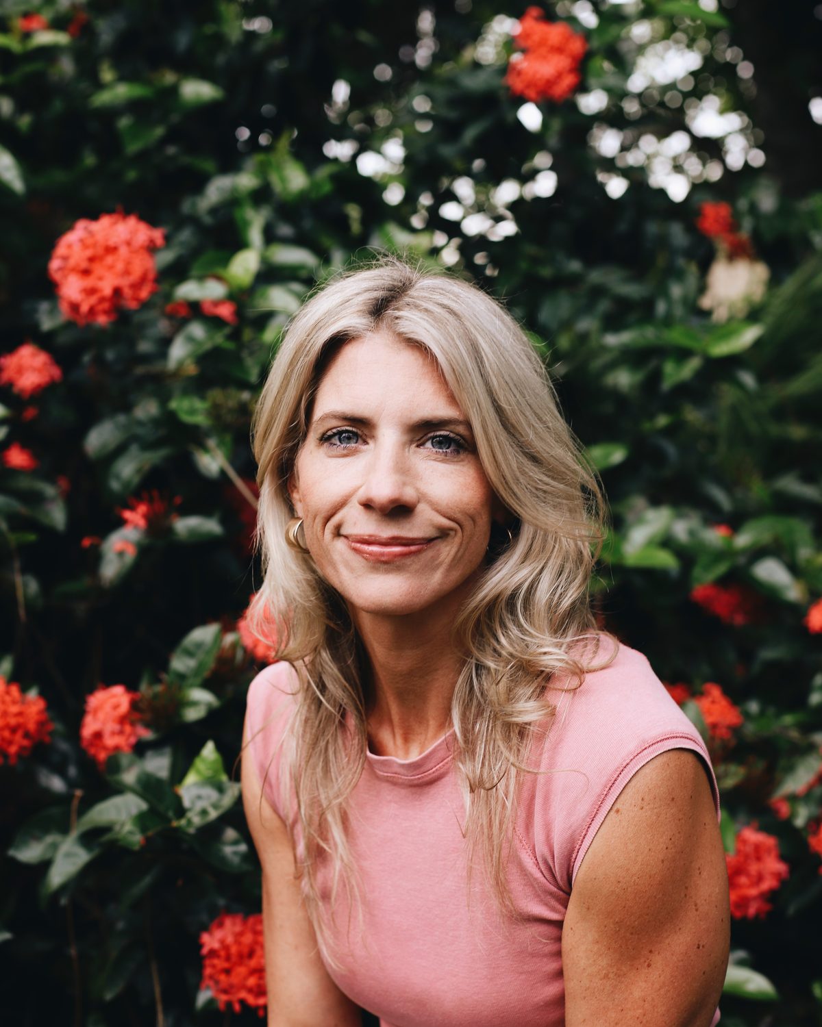 Nicole Shiffler smiling in front of red flowers